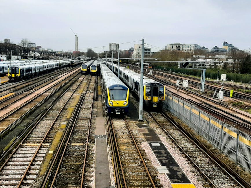 A view of multiple modern passenger trains parked on railway tracks near Hook Railway Station, with some trains in the foreground and others extending into the distance. The trains are primarily silve